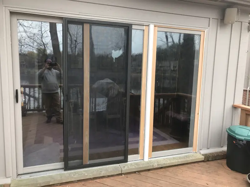 Sliding patio door with new wood trim after a repair